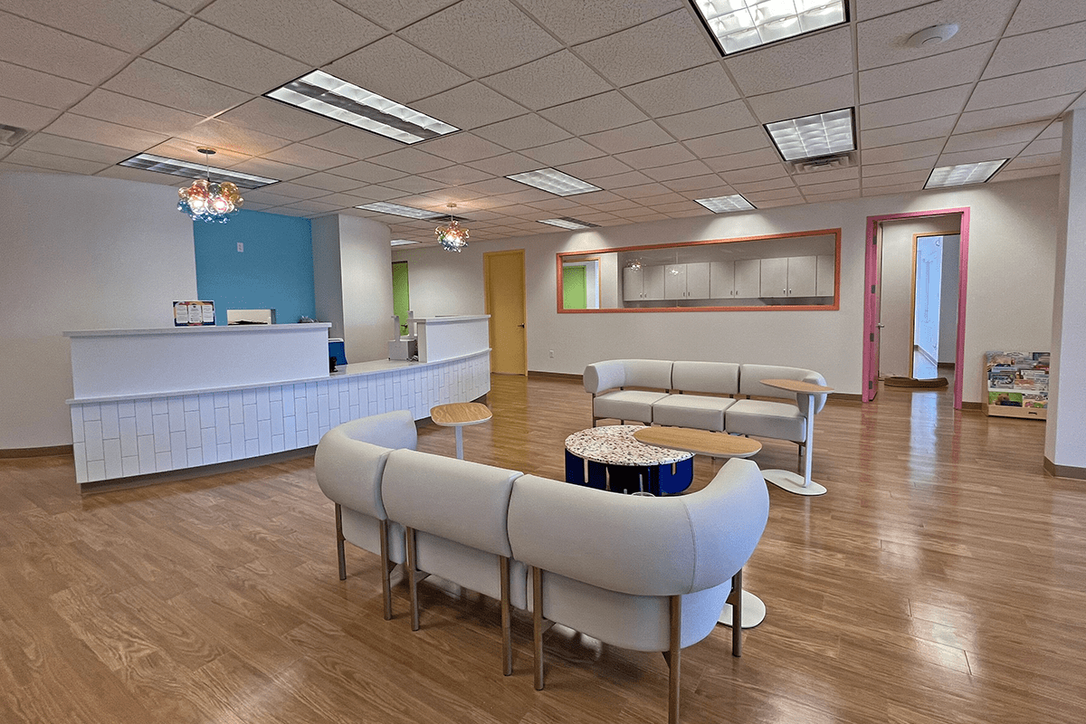 reception/waiting room with colorful accents, couches, check in counter