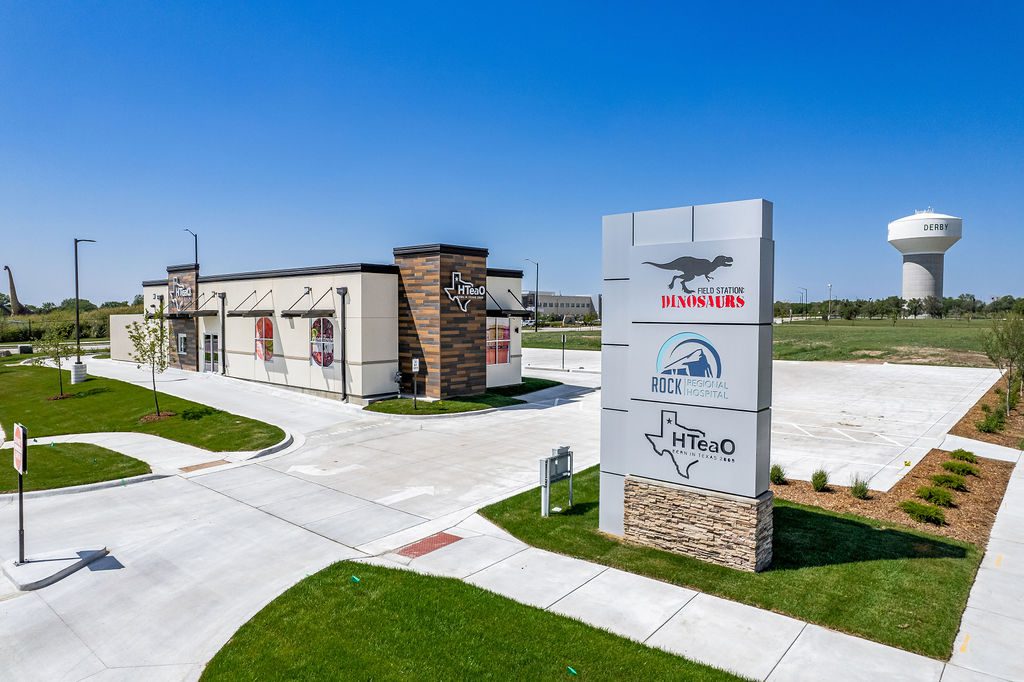 Exterior photo of a white building with wood accents