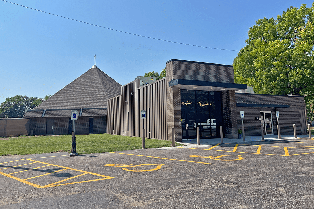 Exterior view of a building with a combination of brick and ribbed metal paneling.